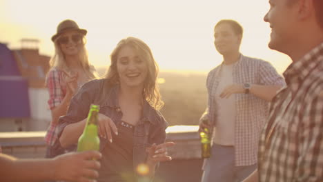 Dancing-girl-rooftop-party-slow-motion-group-of-multiracial-friends-hanging-out-young-asian-woman-dancing-enjoying-roof-top-event-at-sunset-drinking-alcohol-having-fun-on-weekend-celebration